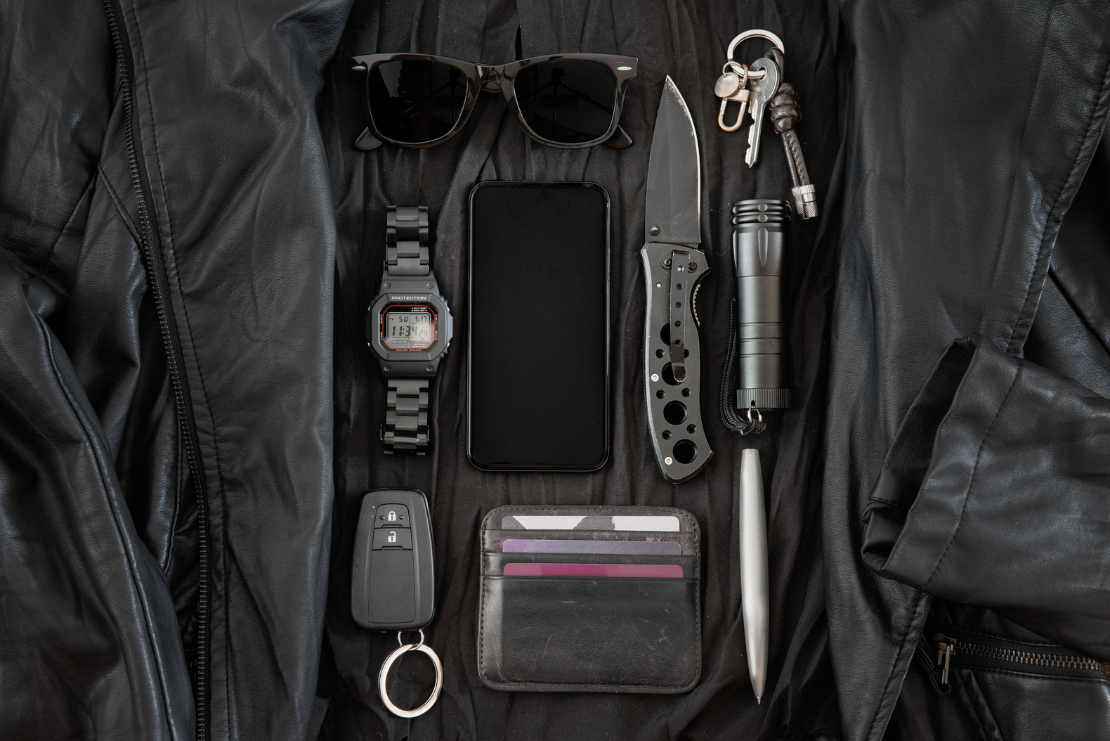 Everyday Carry Items Laid Out on Black Leather Jacket